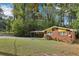 Quaint home featuring brick facade, a covered carport, and lush greenery at 2081 Beecher Sw Rd, Atlanta, GA 30311