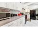 Bright white kitchen cabinets with grey countertops, accented by stainless steel appliances and herringbone tile backsplash at 2081 Beecher Sw Rd, Atlanta, GA 30311