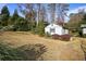 View of the backyard showcasing outbuilding with a stone walkway, mature landscaping and lush grass at 4036 Winding Valley Se Dr, Smyrna, GA 30082