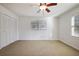 Bedroom featuring neutral carpet, ample closet space, and a ceiling fan with light fixture at 4036 Winding Valley Se Dr, Smyrna, GA 30082