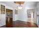 Bright dining room featuring hardwood floors, built-in cabinets, chandelier, and entrance to living spaces at 4036 Winding Valley Se Dr, Smyrna, GA 30082