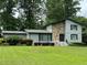 Charming two-story home featuring stone facade, manicured lawn, and lush landscaping at 4036 Winding Valley Se Dr, Smyrna, GA 30082