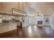 Open-concept kitchen and living area with hardwood floors, brick fireplace, and stainless steel appliances at 4036 Winding Valley Se Dr, Smyrna, GA 30082