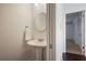 Neutral powder room featuring a pedestal sink, round mirror and view into adjacent hallway at 4036 Winding Valley Se Dr, Smyrna, GA 30082