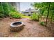 Backyard scene features a stone fire pit, wooded views, and a cozy seating area at 413 Branch Ln, Temple, GA 30179