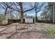 Spacious backyard with mature trees, picnic table, fire pit, privacy fence, and a storage shed in the back at 934 Hope Dr, Atlanta, GA 30310