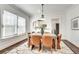Dining room features a modern light fixture, bright windows, and chic wooden dining table and chairs at 934 Hope Dr, Atlanta, GA 30310