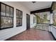 View of the cozy front porch with tile floor, white columns, and black trim at 934 Hope Dr, Atlanta, GA 30310