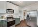 Well-lit kitchen featuring stainless steel appliances, two-tone cabinets, and a door to another room at 934 Hope Dr, Atlanta, GA 30310