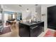 Contemporary kitchen showcasing black cabinetry, stone countertops, gold hardware, and a functional center island with a sink at 1307 Glenwood Se Ave, Atlanta, GA 30316