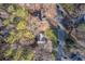 Aerial view shows property surrounded by mature trees with a long driveway and nearby street at 150 Hartwood Dr, Woodstock, GA 30189