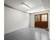 Empty basement room with concrete floors, light walls, and walkout access at 2344 Sagamore Hills Dr, Decatur, GA 30033