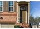 Beautiful brick townhome featuring a front entry with a classic brown door and attached one car garage at 24 Rockland Pl, Decatur, GA 30030
