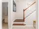 Stylish staircase with hardwood steps and white railing, connecting to a well-lit hallway and nearby bathroom at 24 Rockland Pl, Decatur, GA 30030
