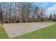 Outdoor basketball court with hoops, set in a landscaped backyard with mature trees at 325 William Falls Dr, Canton, GA 30114