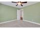 Light green bedroom featuring neutral carpet, a ceiling fan, and a door that opens to the hallway at 325 William Falls Dr, Canton, GA 30114