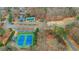 Aerial view of community tennis courts, swimming pool, volleyball and playground amid wooded landscape at 325 William Falls Dr, Canton, GA 30114