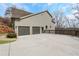 View of the home exterior with a three-car garage, stone accents and a concrete driveway at 325 William Falls Dr, Canton, GA 30114