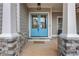 Inviting entryway with a stylish blue double door, stone pillars, and neutral exterior at 325 William Falls Dr, Canton, GA 30114
