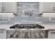 Modern kitchen cooktop with tile backsplash and stainless steel range hood at 325 William Falls Dr, Canton, GA 30114