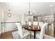 Dining area featuring hardwood floors, an elegant chandelier, and views of the open-concept kitchen at 3538 Davenport Rd, Duluth, GA 30096