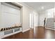 Inviting entryway featuring hardwood floors, a built-in bench with storage, and staircase access to upper floors at 3538 Davenport Rd, Duluth, GA 30096