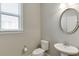 This bathroom features a pedestal sink and a round mirror at 607 Leland Pkwy, Cumming, GA 30041