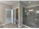 Modern bathroom with gray tile floor and shower featuring stylish glass enclosure and accent tile at 607 Leland Pkwy, Cumming, GA 30041
