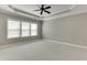 Spacious bedroom features plush carpeting, ceiling fan, and large windows for natural light and comfort at 607 Leland Pkwy, Cumming, GA 30041