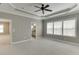 Large bedroom with plush carpeting, ceiling fan, and multiple entryways adding to the spacious atmosphere at 607 Leland Pkwy, Cumming, GA 30041