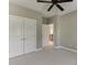 Neutral bedroom featuring plush carpeting, ceiling fan, and double-door closet for optimal storage solutions at 607 Leland Pkwy, Cumming, GA 30041