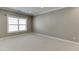 Spacious bedroom features neutral carpet, trim and paint with a large window at 607 Leland Pkwy, Cumming, GA 30041
