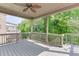 Relaxing covered deck showcasing ceiling fan, neutral color palette, and wooded backyard view at 607 Leland Pkwy, Cumming, GA 30041