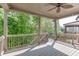 Relaxing covered deck showcasing ceiling fan, neutral color palette, and wooded backyard view at 607 Leland Pkwy, Cumming, GA 30041