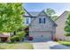 Charming two-story home with stone accents, a well-manicured lawn, and a two-car garage at 607 Leland Pkwy, Cumming, GA 30041