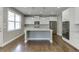 Modern kitchen features white cabinetry, stainless steel appliances, and a center island at 607 Leland Pkwy, Cumming, GA 30041