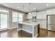 Bright kitchen showcasing a granite island, stainless refrigerator, and hardwood floors at 607 Leland Pkwy, Cumming, GA 30041