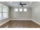 Well-lit living room features hardwood floors, a ceiling fan, and three windows at 607 Leland Pkwy, Cumming, GA 30041