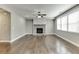 Spacious living room with hardwood floors, stone fireplace, and large windows at 607 Leland Pkwy, Cumming, GA 30041