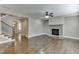 Spacious living room features hardwood floors, stone fireplace, and staircase at 607 Leland Pkwy, Cumming, GA 30041