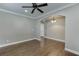 Open-concept living room with hardwood floors, ceiling fan, and arched doorway leading to another room at 607 Leland Pkwy, Cumming, GA 30041
