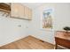 Bright laundry room features wood floors, cabinets and a window with a wooded view at 3784 Robinson Ne Rd, Marietta, GA 30068