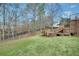 Beautiful backyard featuring green grass, mature trees, and deck with wooden railings at 108 Sweetbriar Ct, Canton, GA 30115