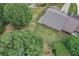 Drone view of a backyard with trees, lawn, and a home with a light-colored roof at 555 Brickleberry Ln, Roswell, GA 30075