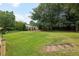 Expansive backyard featuring mature trees, lush green lawn, and a covered patio area at 555 Brickleberry Ln, Roswell, GA 30075