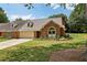 Exterior of a well maintained home featuring a two car garage and green lawn at 555 Brickleberry Ln, Roswell, GA 30075