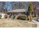 Traditional brick home featuring a well-manicured lawn, small porch, and mature trees at 1210 Stoneybrook Rd, Forest Park, GA 30297