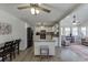 Modern kitchen with granite countertops, white cabinets, and black appliances open to sunroom at 2222 Ivy Crest Dr, Buford, GA 30519