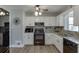 Kitchen featuring white cabinets, granite countertops, and black appliances at 2222 Ivy Crest Dr, Buford, GA 30519