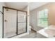 Bright bathroom with a white tiled shower and a large window bringing in natural light at 4110 Ridgebrook Bnd, Cumming, GA 30028